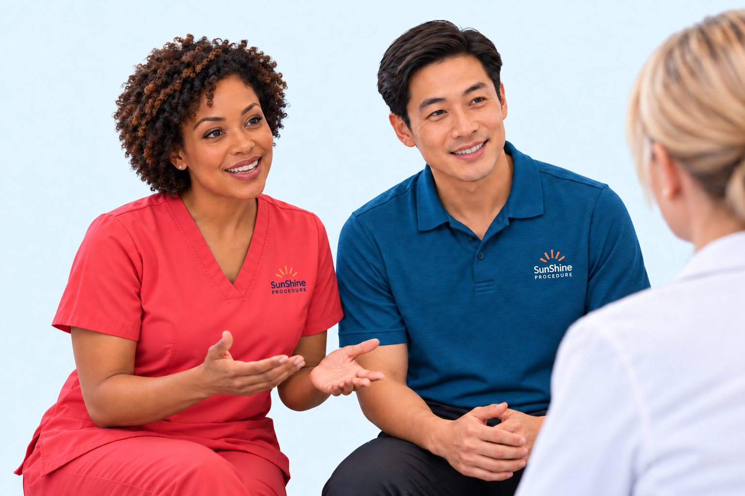 SunShine representatives in coral scrubs and a blue logo polo discussing a demonstration with a physician