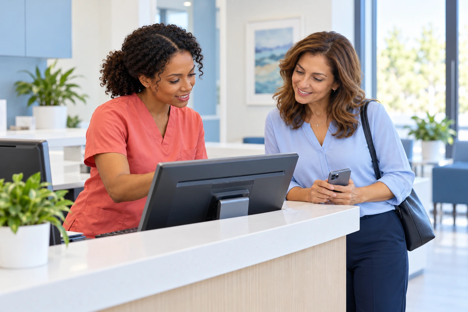 Patient scheduling her next appointment at the front desk with a clinician in red scrubs